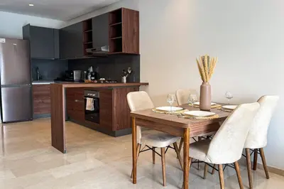 a kitchen and dining room with a wooden table and chairs at Luxury business 70m apartment -CFC AERIA Mall Casa in Casablanca