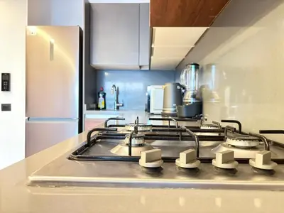 a stove top in a kitchen with a refrigerator at Luxury business 70m apartment -CFC AERIA Mall Casa in Casablanca