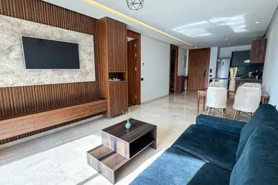 a living room with a blue couch and a tv at Luxury business 70m apartment -CFC AERIA Mall Casa in Casablanca