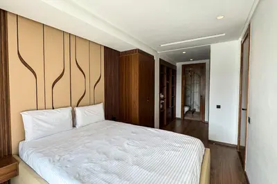 a bedroom with a white bed with a wooden wall at Luxury business 70m apartment -CFC AERIA Mall Casa in Casablanca