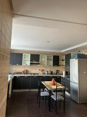 a kitchen with a table with chairs and a refrigerator at Golden Triangle Apartment Rental in Casablanca