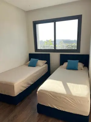 two beds in a room with a window at Luxury 2 bedroom flat in Tamaris Dar Bouazza in Casablanca