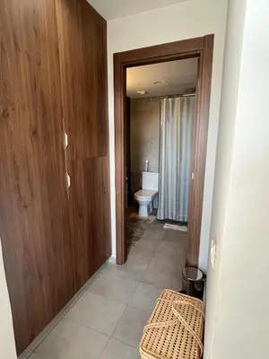 a bathroom with a toilet and a wooden door at Luxury 2 bedroom flat in Tamaris Dar Bouazza in Casablanca