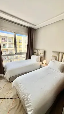a hotel room with two beds and a window at N42 Luxe et Élégance avec Jacuzzi Privatif sur la Corniche Rabat Essabah in Rabat
