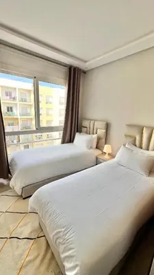 a hotel room with two beds and a window at N42 Luxe et Élégance avec Jacuzzi Privatif sur la Corniche Rabat Essabah in Rabat