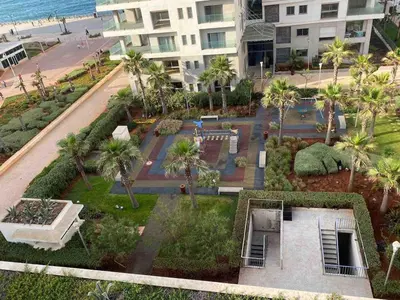 an aerial view of a park with palm trees and a building at Marina Apartment Ocean View BY AppartAyla in Casablanca