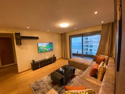 a living room with a couch and a flat screen tv at Marina Apartment Ocean View BY AppartAyla in Casablanca