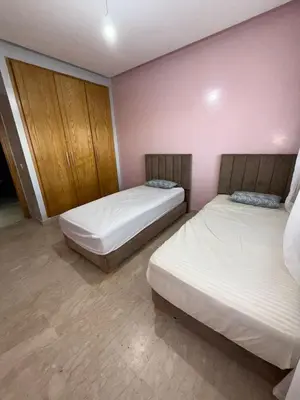 two beds in a room with pink walls at superbe appart a dar bouaza tamaris avec piscine in Casablanca