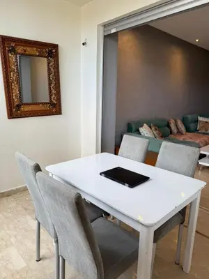 a white table and chairs in a room with a couch at superbe appart a dar bouaza tamaris avec piscine in Casablanca
