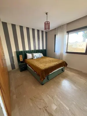 a bedroom with a bed and a striped wall at superbe appart a dar bouaza tamaris avec piscine in Casablanca