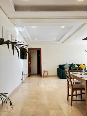 a living room with a couch and a table at SUITOUISS - AGDAL 5 - Appartements à 2 minutes de la gare de train TGV Rabat in Rabat