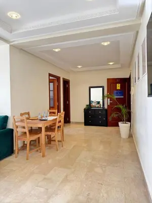 a dining room with a table and chairs at SUITOUISS - AGDAL 5 - Appartements à 2 minutes de la gare de train TGV Rabat in Rabat