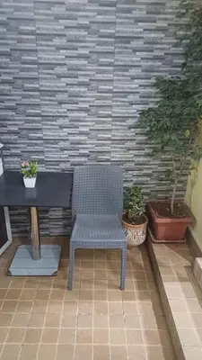 a blue chair sitting next to a table on a patio at Studio confortable in Rabat