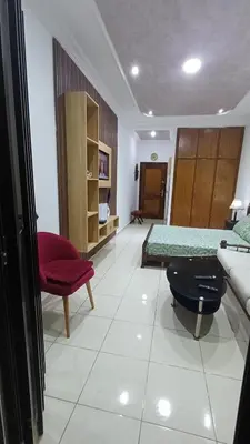 a living room with two beds and a red chair at Studio confortable in Rabat