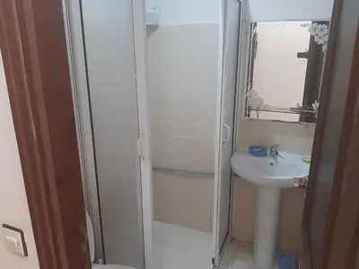 a white bathroom with a sink and a mirror at Studio confortable in Rabat