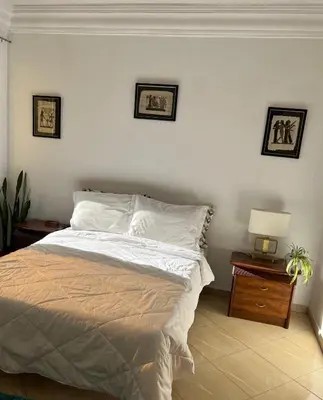 a bedroom with a bed with two pictures on the wall at Private room 2 in Casablanca