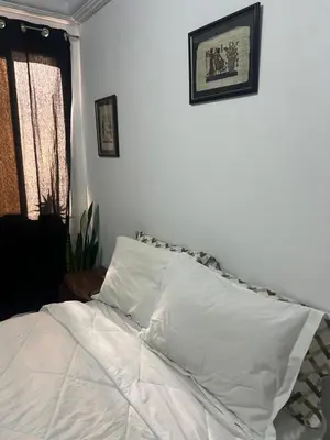 a bed with white sheets and pillows in a bedroom at Private room 2 in Casablanca