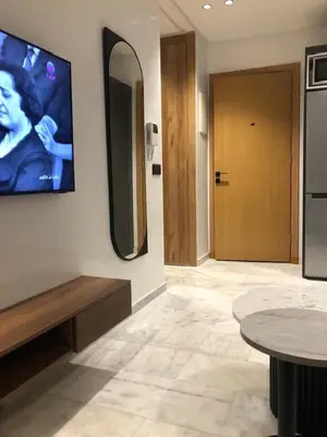 a room with a tv on the wall and a table at AbboGroup APPARTEMENT in Casablanca