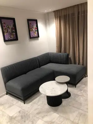 a living room with a black couch and a table at AbboGroup APPARTEMENT in Casablanca