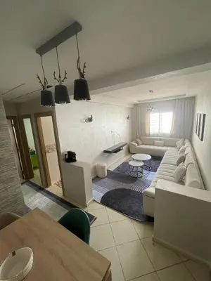 a living room with a couch and a table at Blue Beach & Sunny Life in Skhirate in Skhirat
