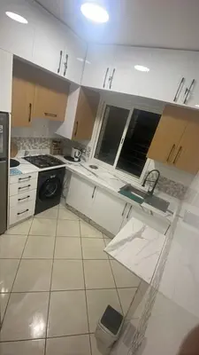 a white kitchen with a sink and a stove at Blue Beach & Sunny Life in Skhirate in Skhirat