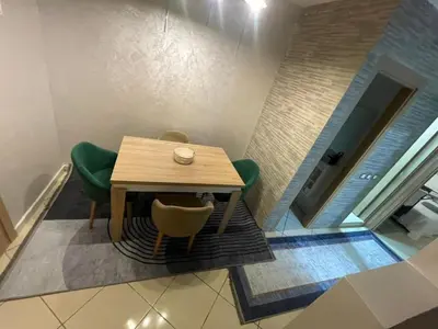 a dining room with a table and green chairs at Blue Beach & Sunny Life in Skhirate in Skhirat