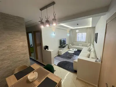 a living room with a couch and a table at Blue Beach & Sunny Life in Skhirate in Skhirat