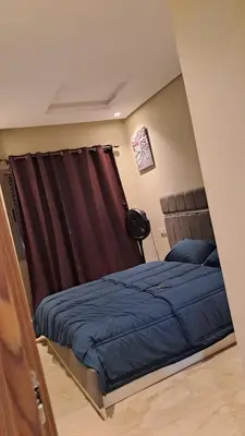 a bedroom with a bed with blue sheets and a curtain at Studio 27 in Casablanca