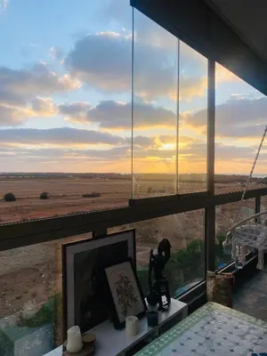 a room with a large window with a view of the desert at Sidi rahal blue beach Cozy apartment with a sea view in Sidi Rahal