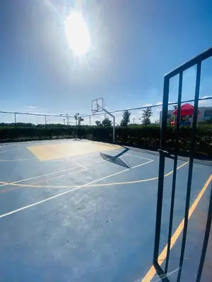 a tennis court with the sun in the sky at Sidi rahal blue beach Cozy apartment with a sea view in Sidi Rahal