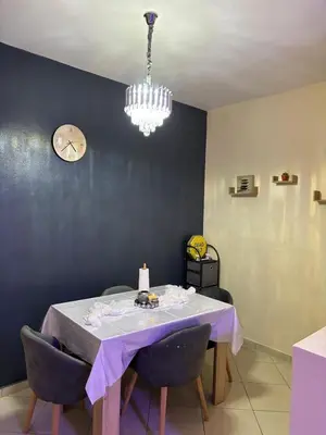 a dining room with a table and a clock on the wall at Appartement skhirat in Skhirat