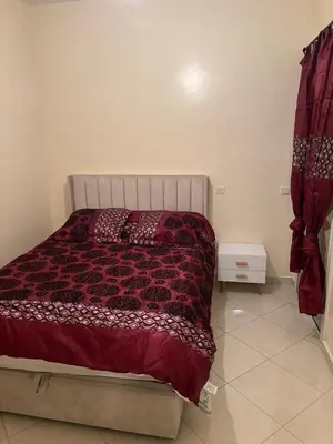 a bedroom with a bed with a red comforter at Appartement skhirat in Skhirat