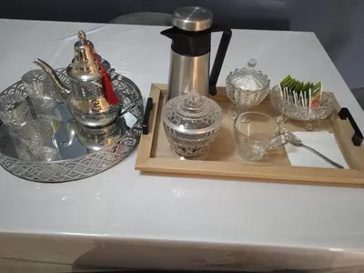a table with a tray of silver dishes and a tea kettle at Appartement skhirat in Skhirat
