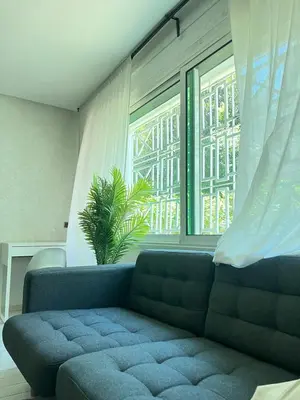 a living room with a blue couch and a window at Stylish apartment - March 2 in Casablanca