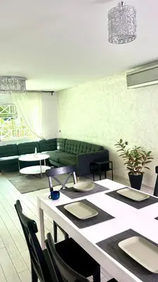a living room with a table and a green couch at Stylish apartment - March 2 in Casablanca