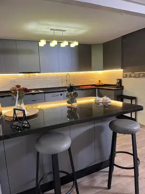 a kitchen with two bar stools at a counter at Stylish apartment - March 2 in Casablanca