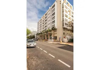 a car parked on a street next to a tall building at Cosy cocon urbain 34 in Rabat