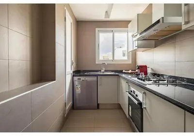 a small kitchen with a sink and a stove at Cosy cocon urbain 34 in Rabat