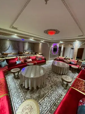 a living room with red couches and tables at Yalla Morocco in Temara