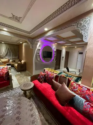 a living room with a red couch and a purple light at Yalla Morocco in Temara
