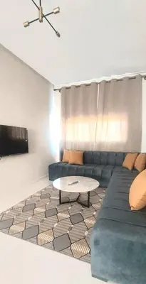 a living room with a couch and a table at Family airport relax apartment in Deroua