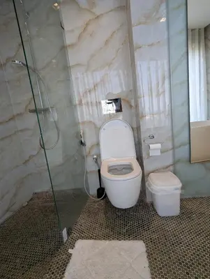 a bathroom with a toilet and a glass shower at Seafront Luxury Villa with Amazing pool! in Dar Bouazza