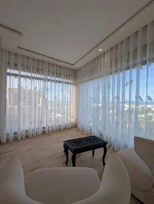 a living room with white furniture and large windows at Seafront Luxury Villa with Amazing pool! in Dar Bouazza
