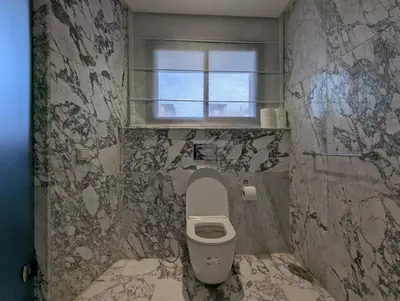 a bathroom with a toilet and a window at Seafront Luxury Villa with Amazing pool! in Dar Bouazza