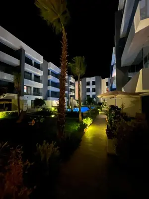 a view of a building at night with palm trees at ZS house harhoura in El Harhoura