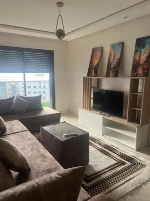 a living room with a couch and a tv at Charmant studio in Casablanca