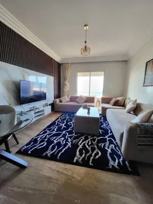 a living room with a couch and a tv at Ailes du vent, coucher de soleil,vue sur mer in Rabat