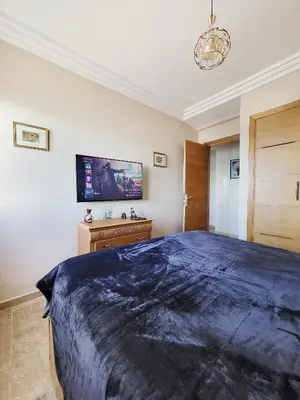 a bedroom with a large bed and a tv on the wall at Ailes du vent, coucher de soleil,vue sur mer in Rabat