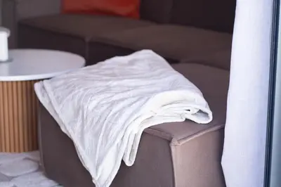 a white blanket sitting on the arm of a couch at Premium Stay - Lux Housing Bourgogne in Casablanca