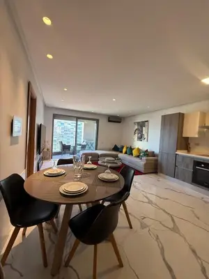 a dining room table and chairs in a living room at Stunning sea-view apartment 20 in Casablanca